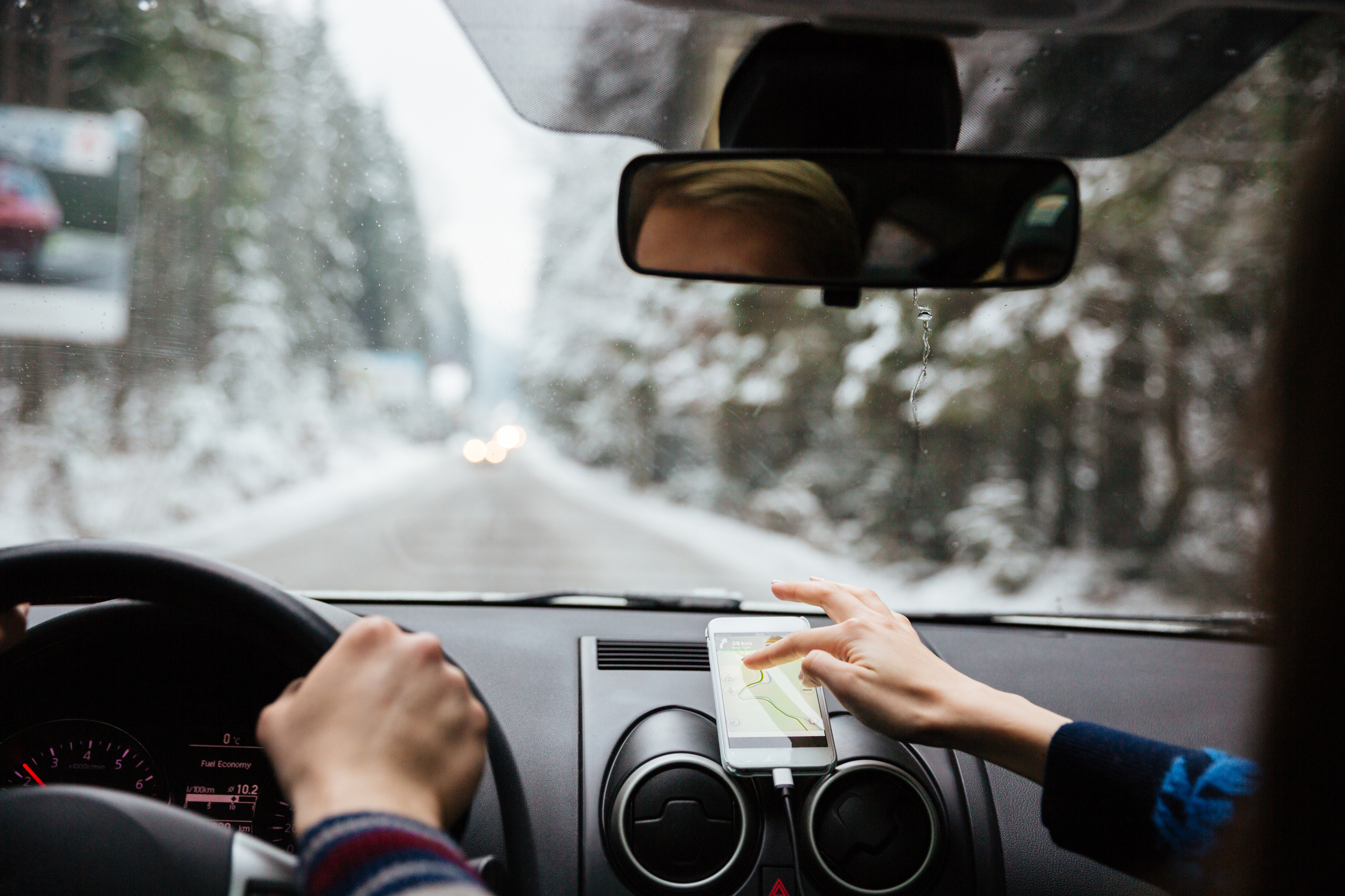 Hands holding smartphone displaying TravelStorys app with mountain landscape